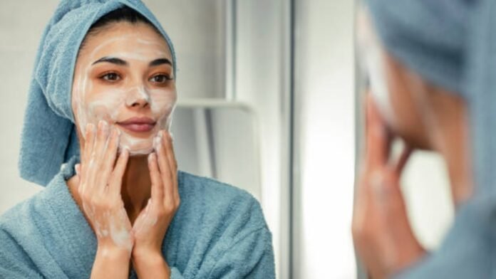 Woman applying night skincare routine for summer skin repair Woman applying night skincare routine for summer skin repair