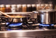 LPG Crisis Hits Hard — 8 Gas-Saving Hacks That Actually Work Indian kitchen gas stove with pressure cooker and covered vessels to reduce LPG consumption